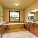 Luxury Bathroom Interior With Granite Trim And Two Vanity Cabinets.
