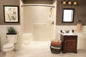 A walk in shower in a modern bathroom with safety products, such as a grab bar and shower seat.
