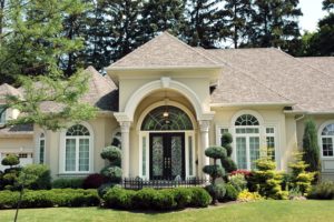 Beige asphalt shingles on a fancy home with a large archway