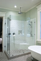 A luxury shower with white tile walls and a glass surround.