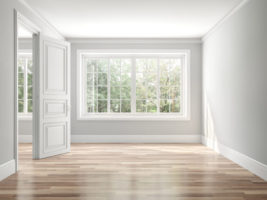 Empty room with wood floors, white walls, and large vinyl windows