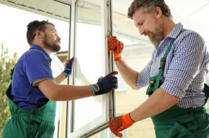 Professional Window Installers Holding a New Casement Window